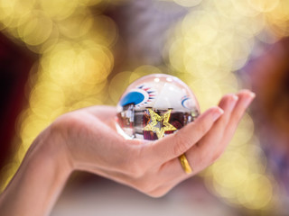 Crystal ball in hand lighting bokeh Chirstmas background blur