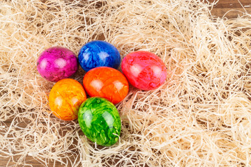 Fototapeta na wymiar Colorful Easter eggs in straw