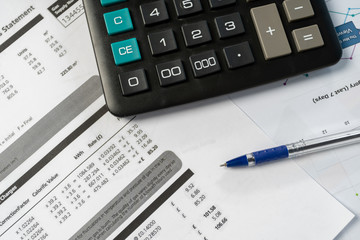 Concept of paying bills. Close up cropped photo with flat lay high angle above top view of object blank calculator and pen