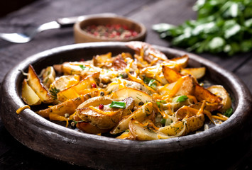Homemade organic vegetable vegan vegetarian baked potato wedges with cheese, chives and dill