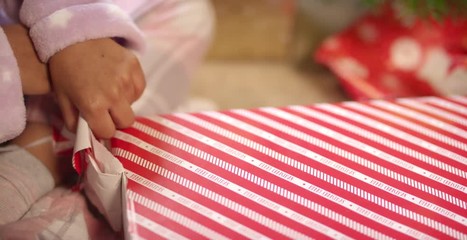 Child Unwrapping Present Close Up