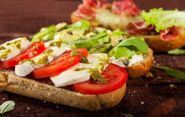 Collection of three different kinds of bruschetta on wooden table.