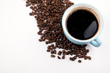 coffee mug with coffee beans on a white table, with copy space