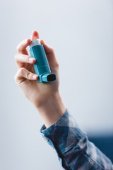 close-up partial view of young woman holding asthma inhaler - obrazy, fototapety, plakaty
