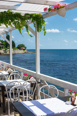 romantic balcony.Tables on terrace in small coastal restaurant with sea view