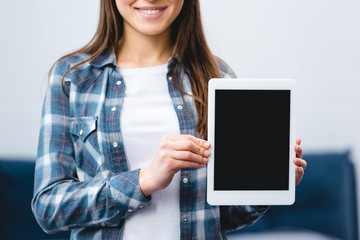 cropped shot of smiling girl holding digital tablet with blank screen