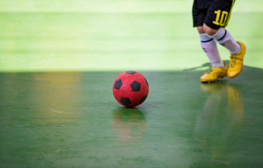 Kid futsal player  trap and control the ball for shoot to goal.