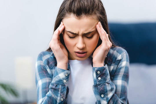 Ill Young Woman Suffering From Headache At Home