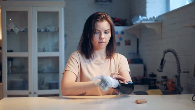 Girl changes batteries of a bionic hand, close up.