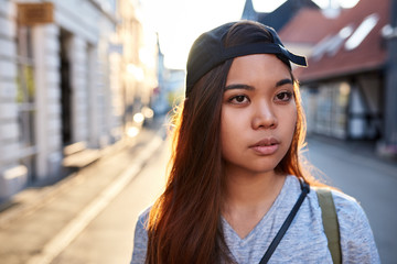 Stylish young Asian woman walking through city streets
