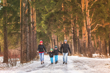Portrait of happy family walking in the winter forest.