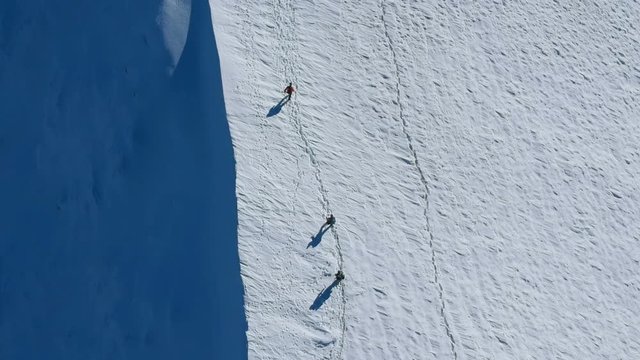 Group of mountaineers climbing up on the mountain at winter