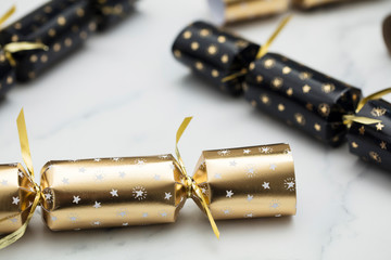 Christmas crackers. luxury gold and black festive crackers on a marble background