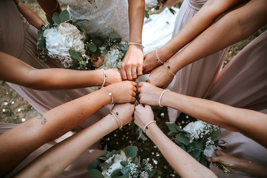 bridesmaids on a wedding putting hands together