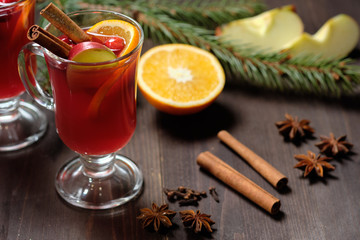 Mulled wine on a wooden background with candles, pine branches and Christmas lights. Selective focus