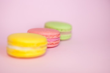 Green, pink and yellow macaroon on pink background, pastel colors