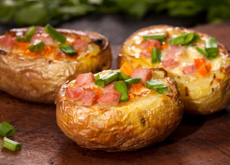 Baked stuffed potatoes with bacon, cheese, chives and spices