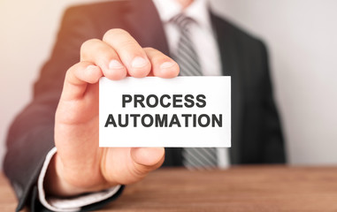 Businessman holding a card with text Process Automation