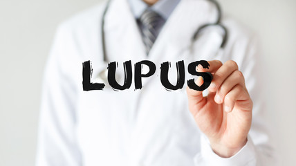 Doctor writing word Lupus with marker, Medical concept