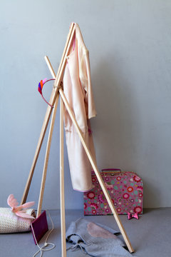 Kinderzimmer Stillife mit Spielsachen und Mode f&uuml;r M&auml;dchen als Tipi vor grauer Wand