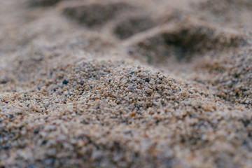 Small coloured stones on the sea beach, coarse sand background