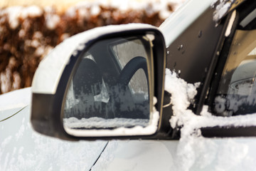 Reflection in the rearview mirror of the car steering and hoarfrost on the window.