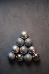 Christmas tree made by silver Christmas balls on the dark background with copy space