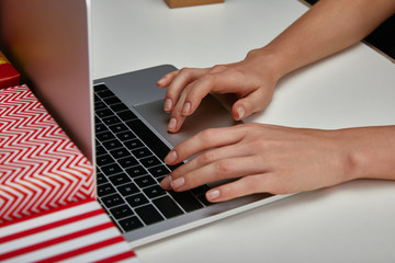 Fototapeta na wymiar Cropped view of woman hands typing on laptop keyboard