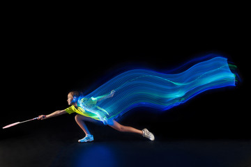 The one caucasian young teenager girl playing badminton at studio. The female teen player on black...