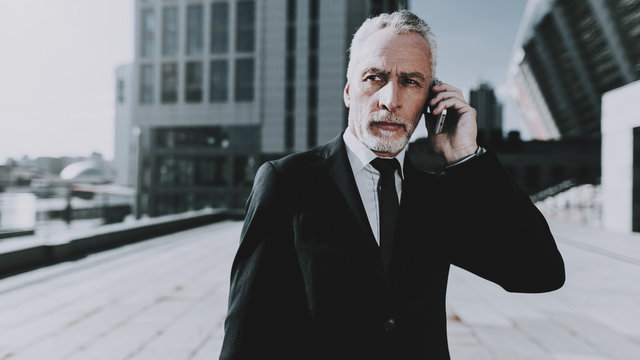 Businessman is Talking on Mobile Phone