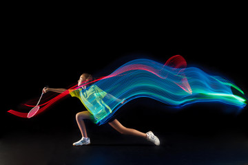 The one caucasian young teenager girl playing badminton at studio. The female teen player on black...