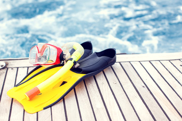 Obraz premium Summertime and holiday concept. Sea view. Diving mask and flippers lelft on boat.