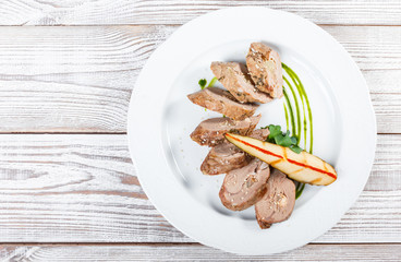 Meat roll stuffed with pear on light wooden background close up. Top view