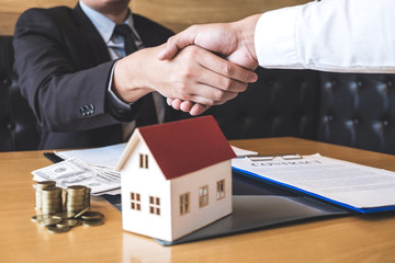 Image of successful deal of real estate, Broker and client shaking hands after signing contract approved application form, concerning mortgage loan offer for and house insurance