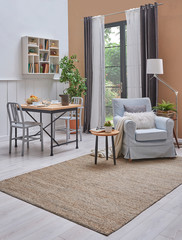 Decorative modern living room, wicker carpet, white shelf, wooden table and blue armchair. Home decoration vertical style.