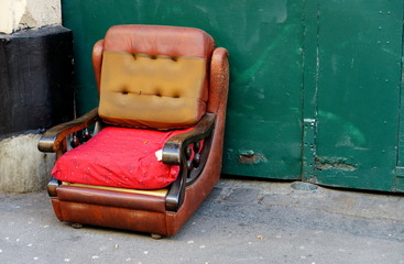 Vieux fauteuil en cuir jeté dans la rue. encombrants