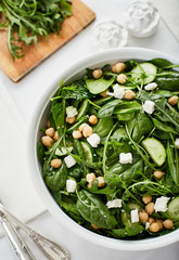green salad, with feta cheese chickpea and cucumber on white table