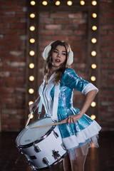 Christmas snow maiden characters playing the drum in the Studio
