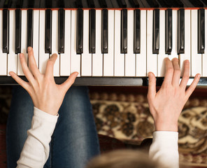 Little girl learning to play the piano.