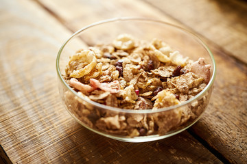Healthy morning breakfast bowl full of organic granola on an old wooden table