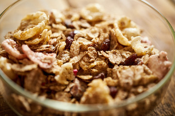 Closeup on a ealthy morning breakfast bowl full of organic granola on an old wooden table