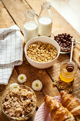 Healthy morning breakfast with different types of breakfast cereal with honey marmalade croissants...