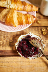 Top view of healthy breakfast with two croissants and marmalade on an old wooden table