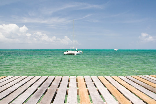 Yacht in front of wooden pier, Caye Caulker, Belize, Caribbean