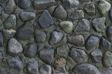 gray stone background, part of wall cobblestones in cement weather-beaten surface texture uneven