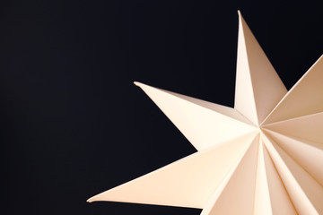 Minimalistic composition with white paper star on colorful background with a lot of copy space for text. Top view, flat lay, closeup. Christmas spirit concept with twinkle star.