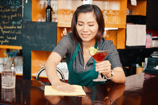 Barwoman Wiping Bar Counter