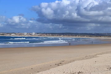 people on the beach with gray sky and full of clouds