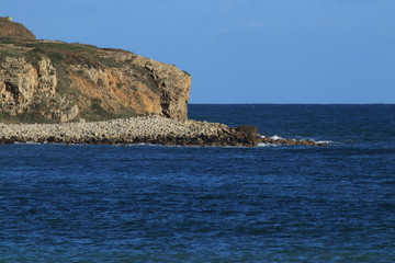 Fototapeta na wymiar rock formation on Peniche beach with blue sky