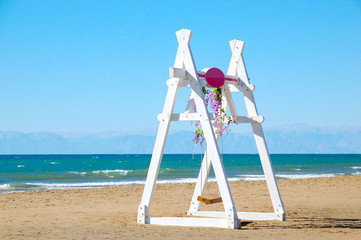 White swings installed by the sea on a sandy beach